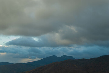 Obraz na płótnie Canvas Mountainous landscape with a cloudy sunset sky