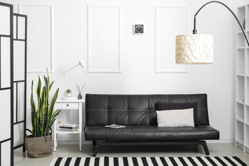 Interior of modern living room with black couch and lamps
