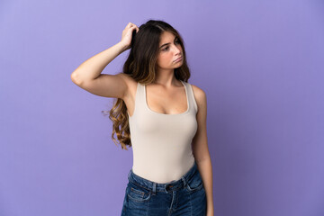 Young caucasian woman isolated on purple background having doubts while scratching head