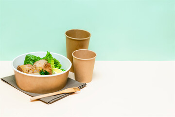 Healthy food lunch in kraft paper carton eco friendly box disposable bowl packaging container, cups on green background. chicken, eggs, greens. Take away delivery. environment protection copy space