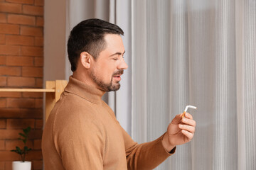 Man with broken cigarette at home. Concept of refusing from bad habit