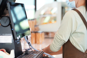 Close up woman cashier using cash register screen to check and pay customer bill in restaurant and coffee shop