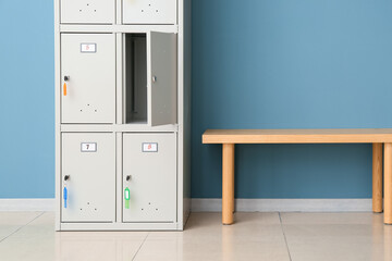 Modern locker and bench near blue wall