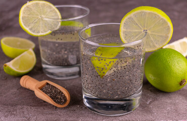 Water with chia seeds and lime on a gray background.