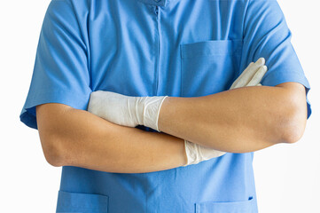 A surgeon wearing a blue uniform stands with his arms crossed on a white background.