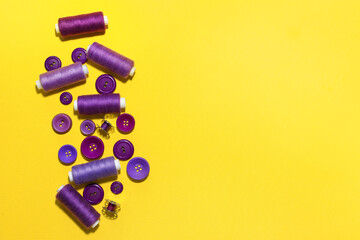 Different sewing threads with buttons on yellow background