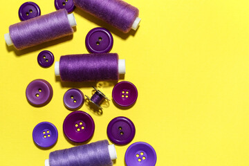 Different sewing threads with buttons on yellow background