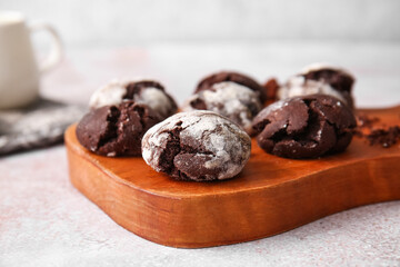 Wooden board of chocolate brownie cookies on light background, closeup