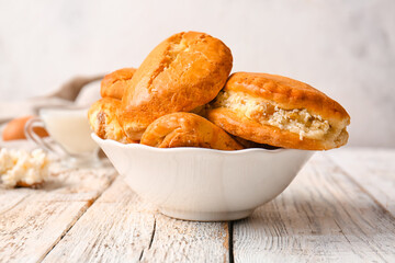 Bowl of tasty sochniki with cottage cheese on table