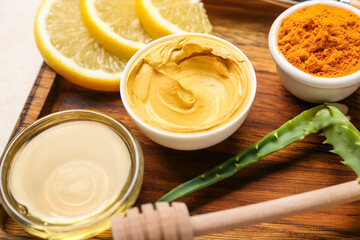 Board with turmeric mask, powder and honey on table, closeup