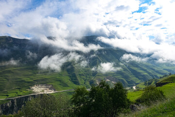 A road in the mountains of Dagestan with large mountains in the background and clouds. Russia.