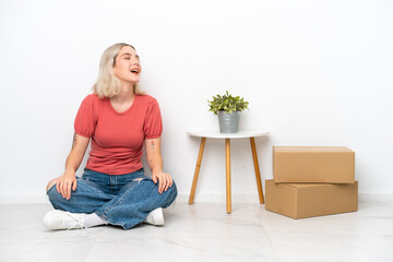 Young woman moving in new home among boxes isolated on white background laughing in lateral position