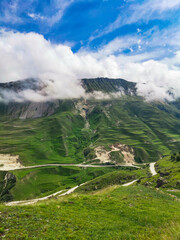 A road in the mountains of Dagestan with large mountains in the background and clouds. Russia.