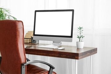 Stylish workplace with modern computer and mobile phone in light room interior