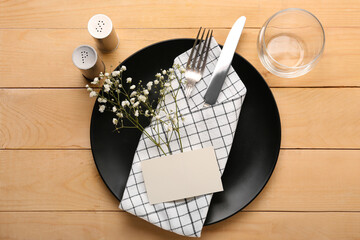 Stylish table setting with blank card and gypsophila flowers on wooden background