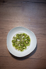 diced kiwifruit in a white bowl on a wooden table