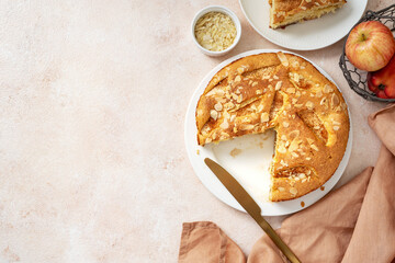 Traditional apple pie on a white plate on a light culinary background. Charlotte pie on a platter. Delicious homemade pastry on the kitchen table. Top view