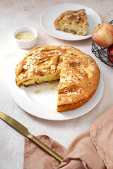 Traditional apple pie on a white plate on a light culinary background. Charlotte pie on a platter closeup. Delicious homemade cakes on the kitchen table