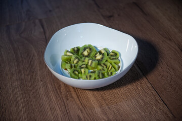 diced kiwifruit in a white bowl on a wooden table