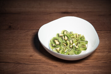 diced kiwifruit in a white bowl on a wooden table