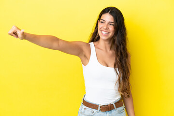 Young caucasian woman isolated on yellow background giving a thumbs up gesture