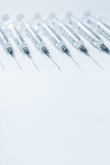 Vaccination. Row of syringes on white.