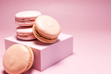 The macaroons are pink and orange and the decor is pink on a light pink background.