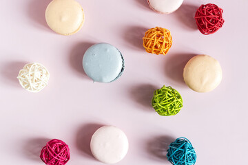 Colored macaroons p and colored decor on a light pink flat lei background.