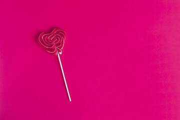 A bright red lollipop on a red background is a place for text.