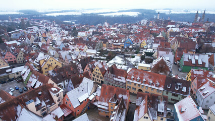 Fototapeta premium Aerial View: Rooftops with snow in Rothenburg ob der Tauber, Bavaria. Rothenburg is one of the famous tourist attractions in Germany. It’s well known for its well-preserved medieval old town.