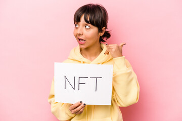 Young hispanic woman holding a NFT placard isolated on pink background showing a mobile phone call gesture with fingers.