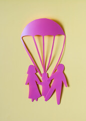 Abstract cardboard family of three and a rescue parachute.
