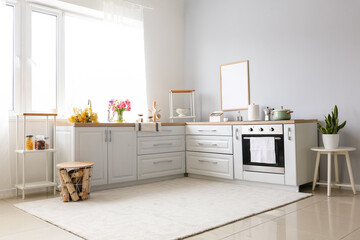Interior of modern kitchen with stylish counters and beautiful flowers