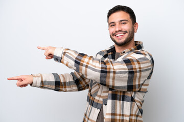 Young Brazilian man isolated on white background pointing finger to the side and presenting a product