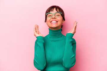 Young hispanic woman isolated on pink background laughs out loudly keeping hand on chest.