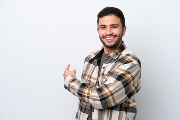 Young Brazilian man isolated on white background pointing back