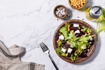Healthy spring salad beet with spinach, cheese feta and chickpeas on a marble tabletop. Top view flat lay. Copy space.