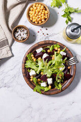 Healthy spring salad beet with spinach, cheese feta and chickpeas on a marble tabletop. Top view flat lay. Copy space.