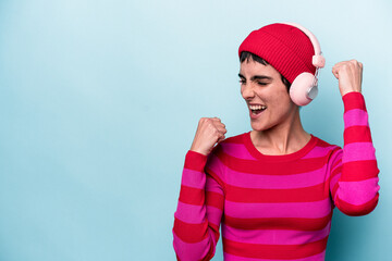 Young caucasian woman listening to music isolated on background raising fist after a victory, winner concept.