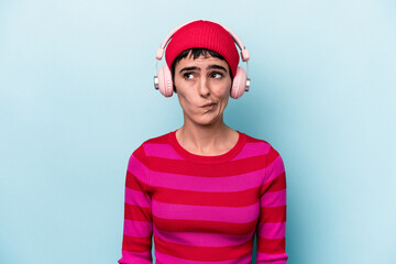 Young caucasian woman listening to music isolated on background confused, feels doubtful and unsure.