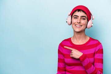 Young caucasian woman listening to music isolated on background smiling and pointing aside, showing something at blank space.