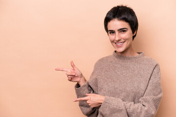 Young caucasian woman isolated on beige background excited pointing with forefingers away.