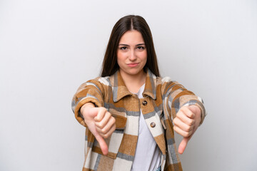 Young girl isolated on white background showing thumb down with two hands