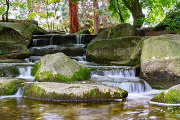 Fototapeta na wymiar Small waterfall in public zen garden