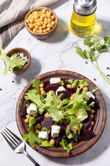 Healthy spring salad beet with spinach, cheese feta and chickpeas on a marble tabletop.