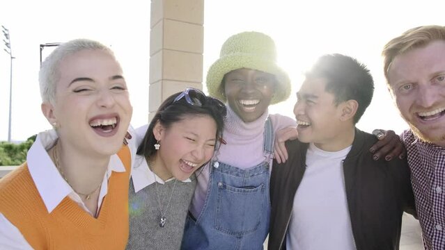 Multiracial group of people smiling at camera together - Best friends having fun on city street - Guys and girls laughing together - Youth lifestyle and happiness concept