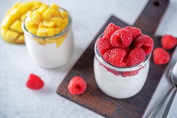 Set of Greek yogurt mango and raspberry parfait in jars