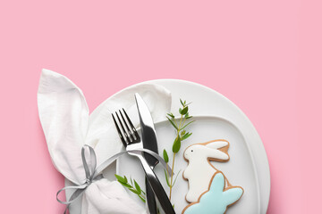 Stylish table setting with Easter cookies on pink background