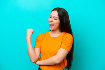 Young caucasian woman isolated on blue background celebrating a victory