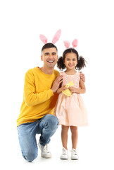 Little African-American girl with Easter rabbit and her father on white background